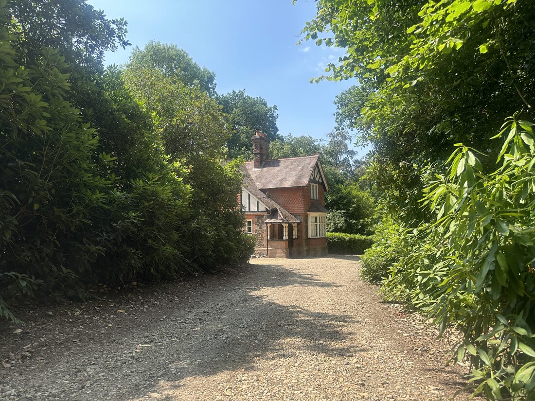 Victorian lodge along a wooded drive